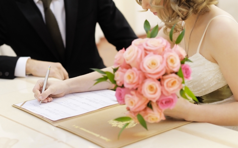 coppia appena sposata firma il contratto di matrimonio